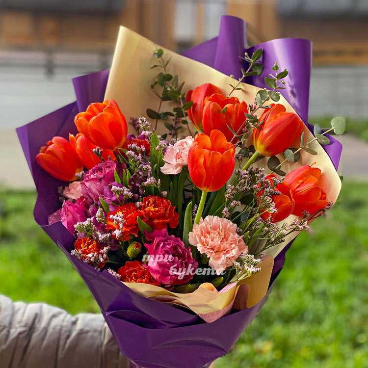 Яркий букет оранжевых тюльпанов и гвоздик (крупный план)